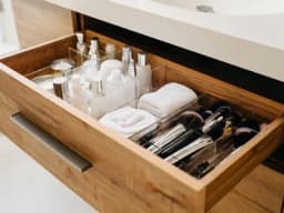 Eine perfekt organisierte Badezimmerschublade mit transparenten Acrylboxen für Kosmetik.